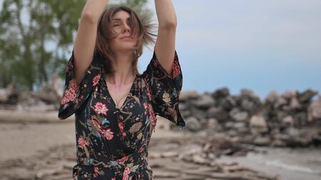 Young beautiful woman dancing on the seashore