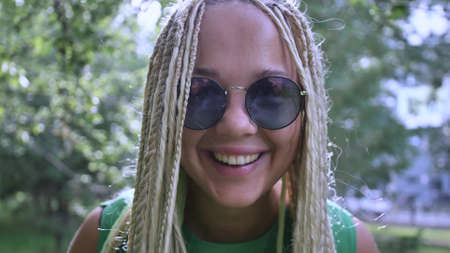 Closeup portrait of a cheerful young woman with white long dreadlocksの写真素材