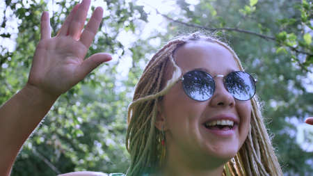 Closeup portrait of a cheerful young woman with white long dreadlocksの写真素材