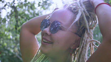 Closeup portrait of a cheerful young woman with white long dreadlocks