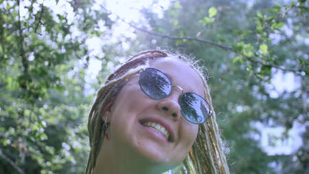Closeup portrait of a cheerful young woman with white long dreadlocksの写真素材