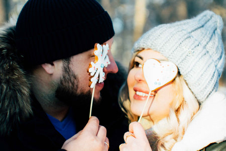 A loving couple walks in a winter park. Lovely happy lovers enjoying time together. Winter holidays...
