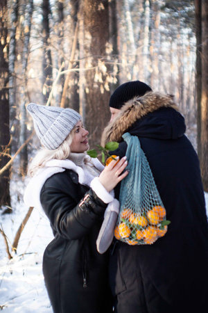 A loving couple walks in a winter park. Lovely happy lovers enjoying time together. Winter holidays...
