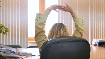Business woman in the office. Confident business woman relaxing on a chair in her office.