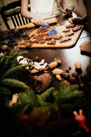 two cute sisters and mom sculpt and decorate Christmas gingerbreadの写真素材