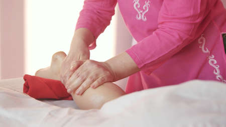 Young woman getting a foot and foot massage with oil at the spa of the resort. Woman receiving body massage at the spa. Body relaxation and skin care.の写真素材