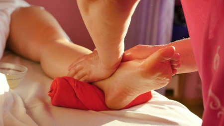 Young woman getting a foot and foot massage with oil at the spa of the resort. Woman receiving body massage at the spa. Body relaxation and skin care.の写真素材