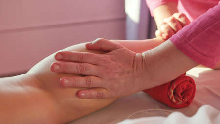 Young woman getting a foot and foot massage with oil at the spa of the resort. Woman receiving body massage at the spa. Body relaxation and skin care.の写真素材