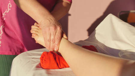 Young woman getting a foot and foot massage with oil at the spa of the resort. Woman receiving body massage at the spa. Body relaxation and skin care.の写真素材