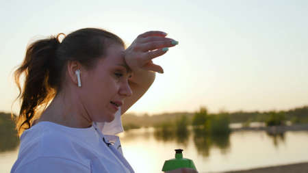beautiful woman runner athlete resting exhausted after intense running workout on beach tired female...