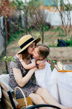 In the spring, mother and daughter spend too much time in the apple orchard. Happy family conceptの写真素材