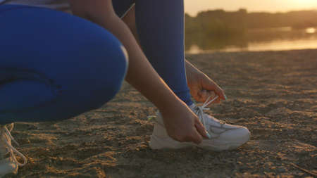 Woman ties shoelaces and runs athlete jogging sport fitness foot speed activity foot health health shoes female exercise healthy.の写真素材