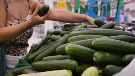 Woman buying fresh cucumbers at the supermarket.の写真素材
