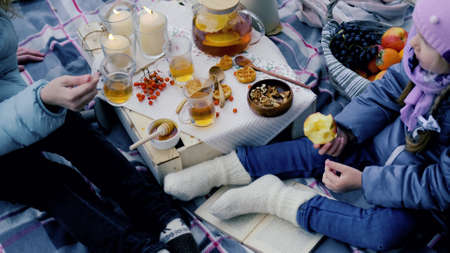 young mother and daughter on a picnic in nature eat fresh honey. close-up