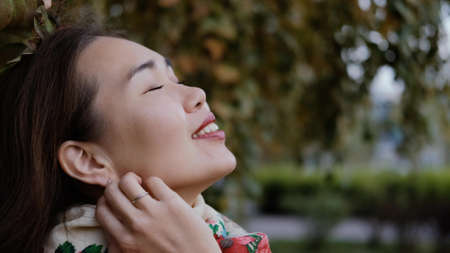 Happy smiling woman looking up to the sky and breathing fresh autumn air.の写真素材