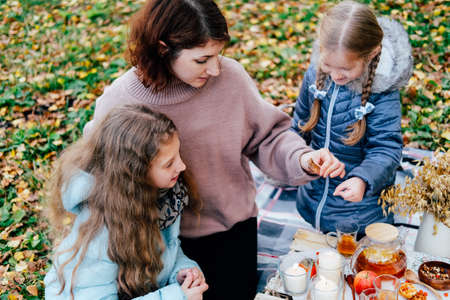young mother and daughter on a picnic in nature eat fresh honey. close-upの写真素材
