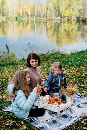 young mother and daughter on a picnic in nature eat fresh honey. close-upの写真素材