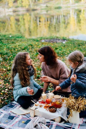 young mother and daughter on a picnic in nature eat fresh honey. close-upの写真素材