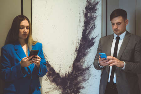 Pair of executives looking at something on a cellphone