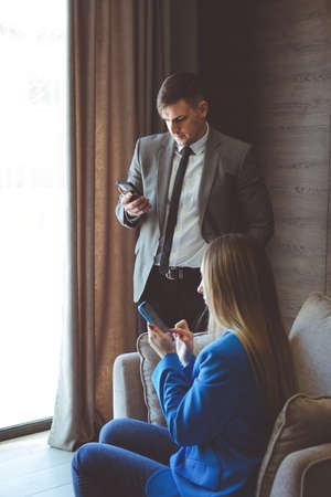 Pair of executives looking at something on a cellphone