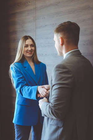 Business woman and businessman shake hands. Business partnership concept.