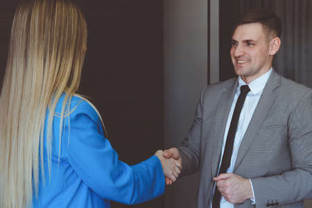 Business woman and businessman shake hands. Business partnership concept.