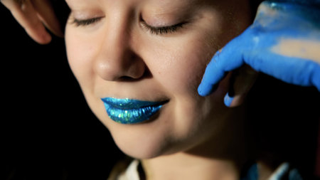 Paint on the face and body of a woman. A woman in the spotlight poses for the camera. Body art.の写真素材