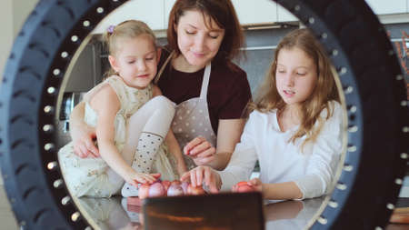 Easter. Mom and two cute daughters are preparing at home for the traditional spring holiday. The...