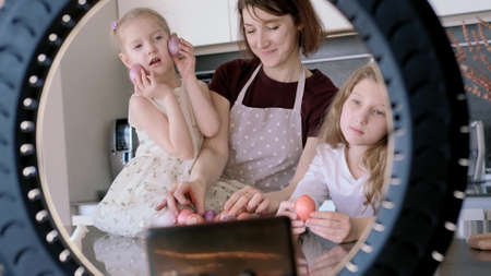 Easter. Mom and two cute daughters are preparing at home for the traditional spring holiday. The...