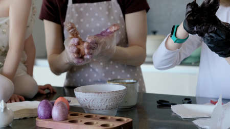 Happy Easter. Mom and two cute daughters paint eggs for the traditional spring holiday at home