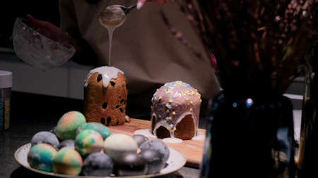 Cooking a traditional Easter cake. A woman decorates holiday pastries. Close-up.の写真素材