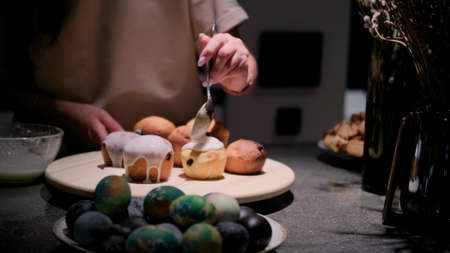 Cooking a traditional Easter cake. A woman decorates holiday pastries. Close-up.の写真素材