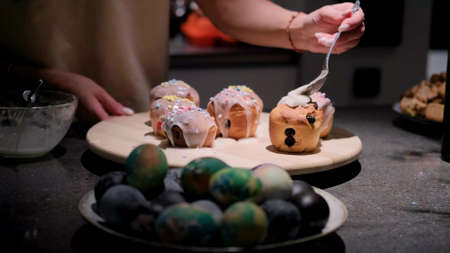 Cooking a traditional Easter cake. A woman decorates holiday pastries. Close-up.の写真素材