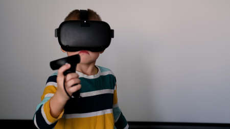 Portrait of kid VR gamer. Child in vr gadgets set, helmet and goggles. Little boy in virtual...