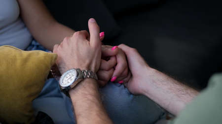 Close-up of the hands of a man and a woman. Male hands stroking the hands of a young woman stroking. Love and support conceptの写真素材