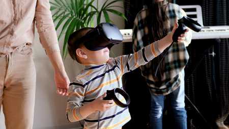 Mom and son use virtual reality glasses while playing virtual games at home. Family entertainment concept.の写真素材
