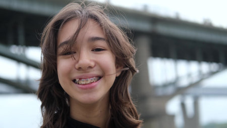 Portrait of a young girl who smiles happily with braces on her teeth. Portrait of a teenager on a...
