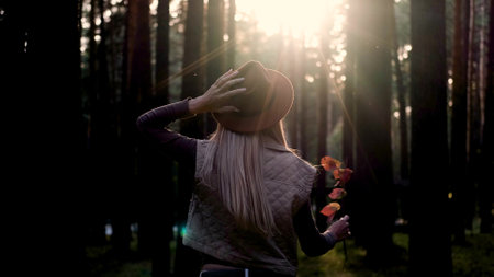 Hippie woman spinning around and enjoying life with a smile on her face outdoors in the forest. Beautiful caucasian woman relaxing in natureの写真素材