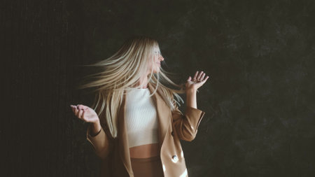 Portrait of a happy victorious, cheerful and carefree woman. Blonde business woman in looking at the camera, dancing to the music, moving her hands, hey, dancing, having fun. Victoryの写真素材