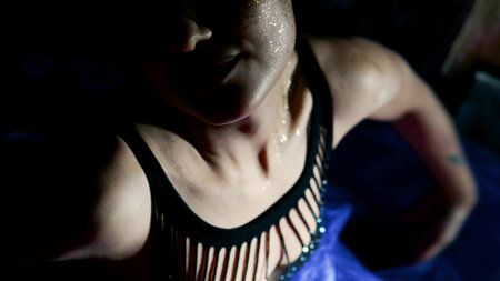 A beautiful brunette moves in a slow dance at night. The body of a woman is decorated with sparkles...