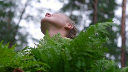 A young woman in a yellow raincoat walks through the forest, breathes clean air. Portrait of a woman...