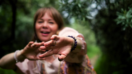 Beautiful young gypsy woman dancing with her hands with boho decorations. Portrait of a dancing girl in a pink long dress. The concept of femininity.の写真素材