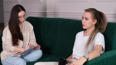 A woman psychotherapist conducts a reception in her office. The patient expresses her feelings in a one-on-one relationship with a specialist. Mental health conceptの写真素材
