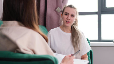 A woman psychotherapist conducts a reception in her office. The patient expresses her feelings in a one-on-one relationship with a specialist. Mental health conceptの写真素材
