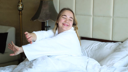 Pretty happy woman waking up in bed at home enjoying her vacation. Beautiful caucasian woman is resting on the bed. Sleep and rest conceptの写真素材