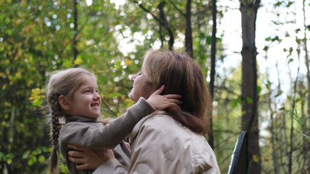 Hello September. A young mother and little daughter walk in the city park in autumn.の写真素材