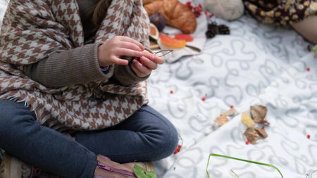 Young mother with her little daughter in the autumn park on a picnic. Close-upの写真素材