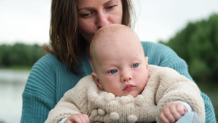 A woman and a little boy on a walk by the river. Mother holds her son in her arms.の写真素材