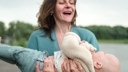 A woman and a little boy on a walk by the river. Mother holds her son in her arms.の写真素材