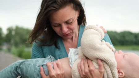A woman and a little boy on a walk by the river. Mother holds her son in her arms.